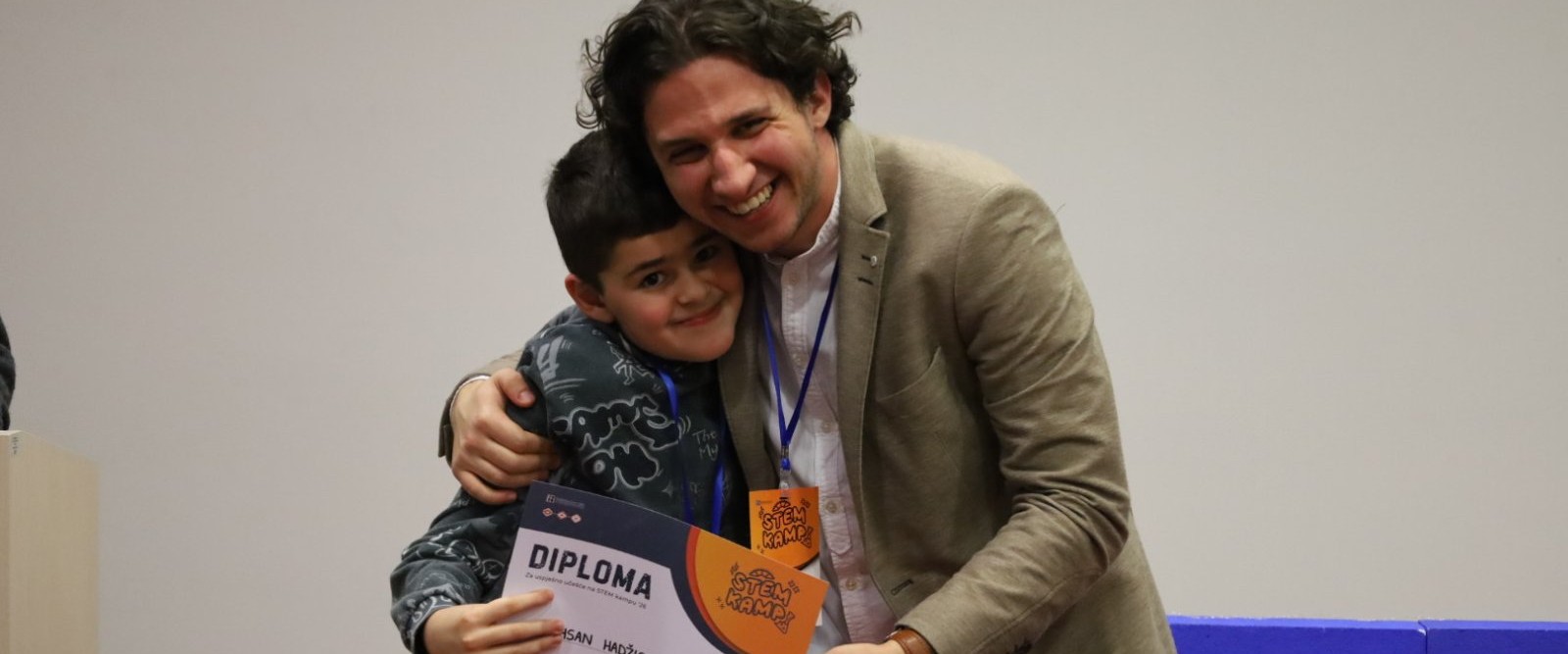 Usama Khedr grli polaznika STEM kampa koji drži diplomu
